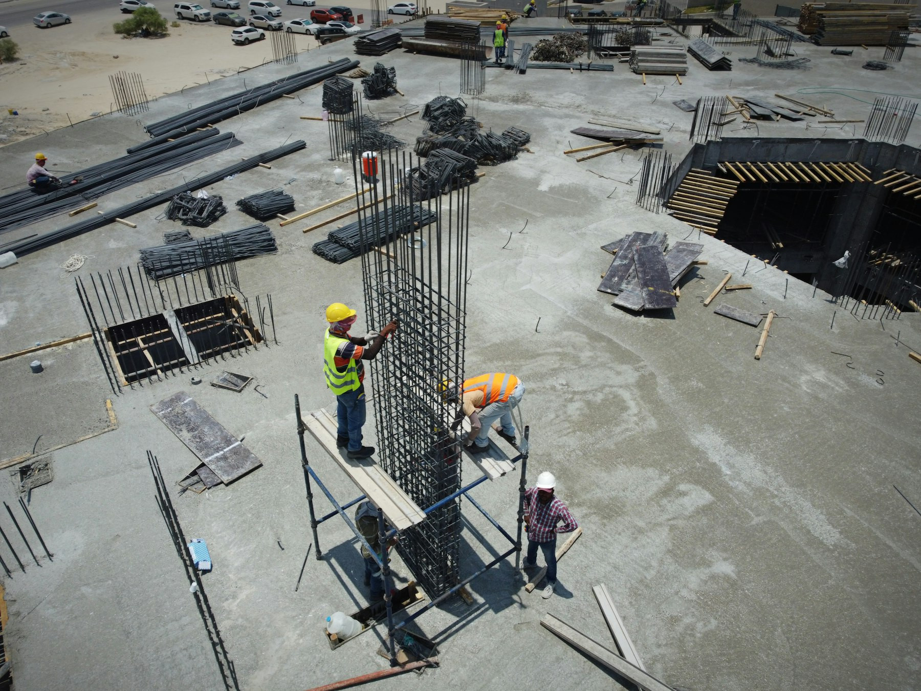 Aerial view of workers fixing rebar on a large construction site